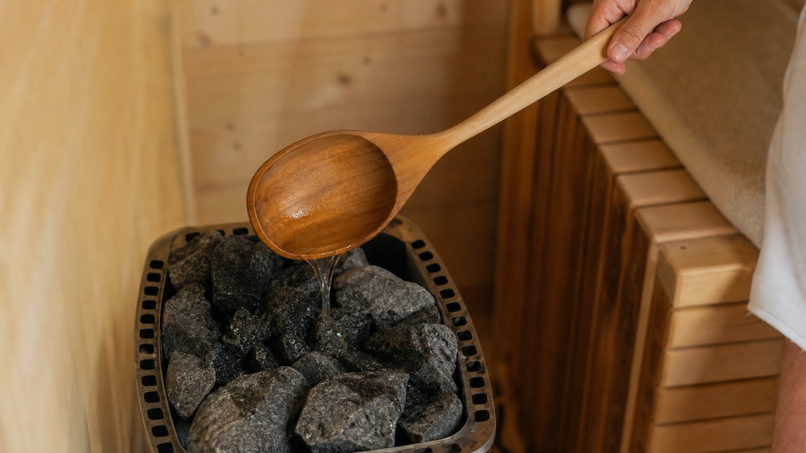 Poêle de sauna chargé de pierres chauffant une cabine de bois clair